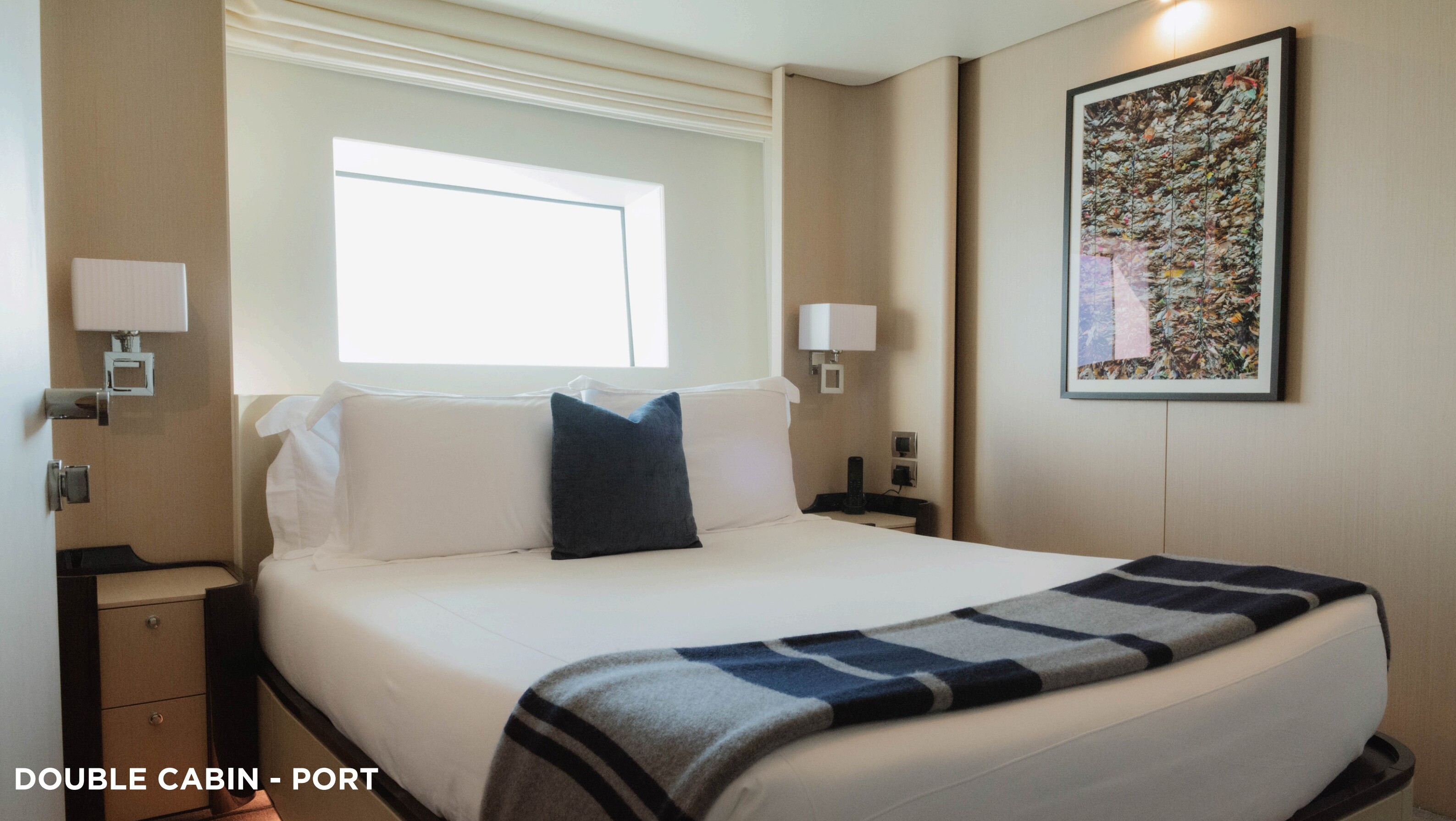 Double guest cabin with neutral linens and artwork